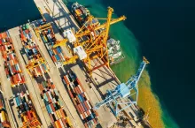 Containers in international shipping dock waiting to import or export and transportation. Top view of loading containers on the ship in the port.