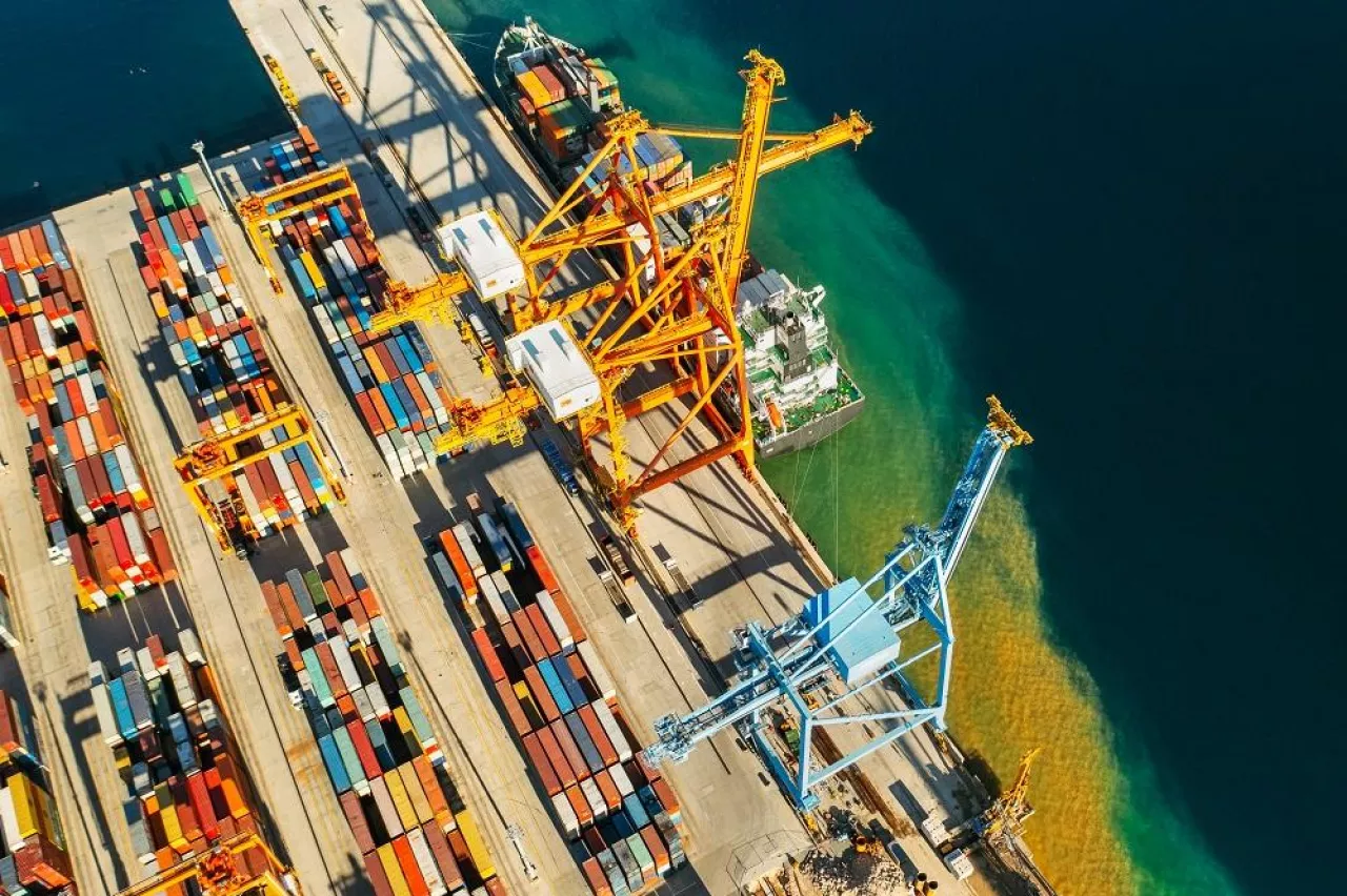 Containers in international shipping dock waiting to import or export and transportation. Top view of loading containers on the ship in the port.