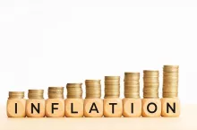 Inflation concept. Text on wooden blocks and stacked coins. Copy space