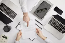 top view of businessman pointing to contract to clerk