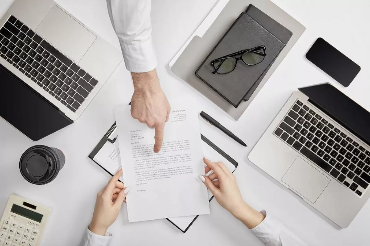 top view of businessman pointing to contract to clerk