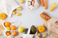 Zero Waste food shopping and storage in cotton eco bags. Glass jars with grains, reusable bags with fresh vegetables, fruits. Sustainable, ethical, plastic free lifestyle. Top view, flat lay