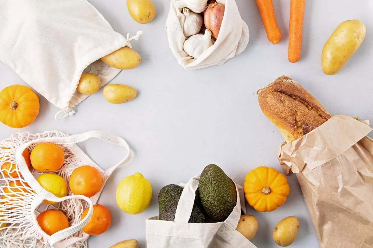 Zero Waste food shopping and storage in cotton eco bags. Glass jars with grains, reusable bags with fresh vegetables, fruits. Sustainable, ethical, plastic free lifestyle. Top view, flat lay