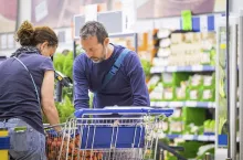 Daily real couple buy food and beverages at the big store market after work - together forever in relationship during normal lifestyle - family coucept for cacuasian people spending money to live