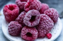 A closeup shot of frozen raspberries in a plate on the table