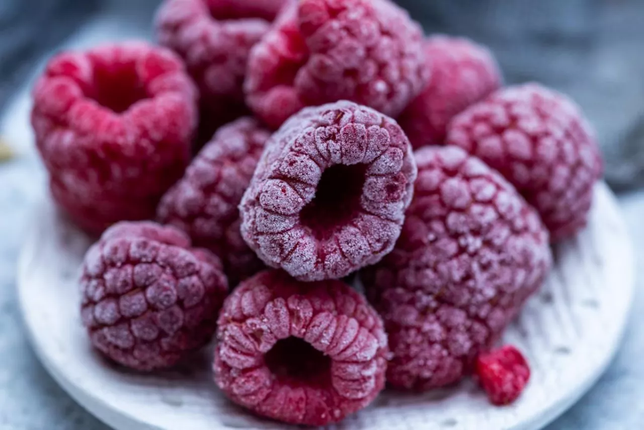 A closeup shot of frozen raspberries in a plate on the table